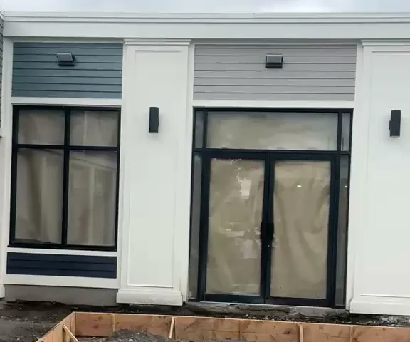 Puertas dobles de vidrio con marco negro instaladas por Instalaciones Lara