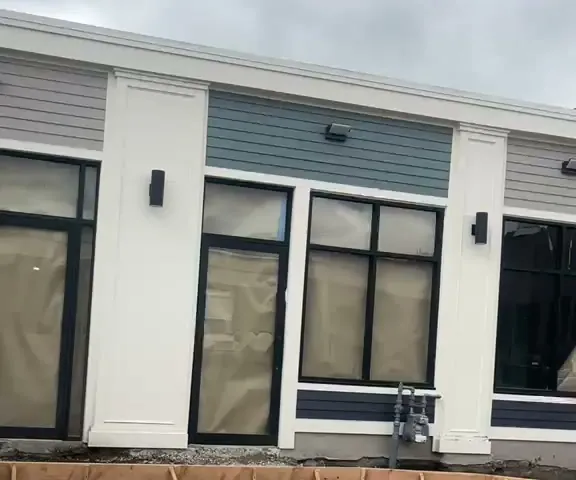 Ventanas nuevas de marco negro instaladas por Instalaciones Lara en un local